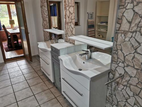 un bagno con due lavandini e un muro di pietra di Apartment Seascape - Self Check-In a Duisburg