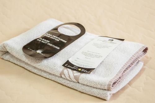 a towel with a book on top of it at Hotel Londri Star in Londrina
