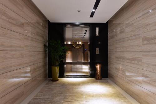 a hallway with a door with a plant in it at Lavande Hotel Huizhou High-speed Railway South Station Wanlian Square in Huizhou