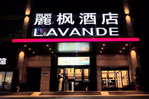 a building with a lit up sign in front of it at Lavande Hotel Huizhou High-speed Railway South Station Wanlian Square in Huizhou