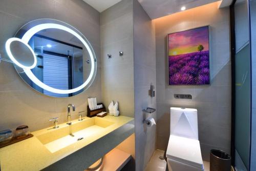 a bathroom with a sink and a mirror at Lavande Hotel Huizhou High-speed Railway South Station Wanlian Square in Huizhou