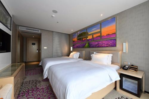 Habitación de hotel con 2 camas y TV de pantalla plana. en Lavande Hotel Huizhou High-speed Railway South Station Wanlian Square, en Huizhou