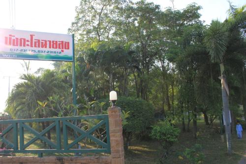a sign on a fence with trees in the background at Chaisuk Bungalow in Aranyaprathet