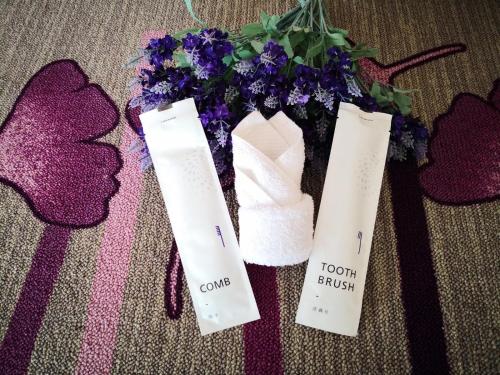 a vase filled with purple flowers next to two tags at Lavande Hotel Yinchuan Railway Station Wanda in Yinchuan