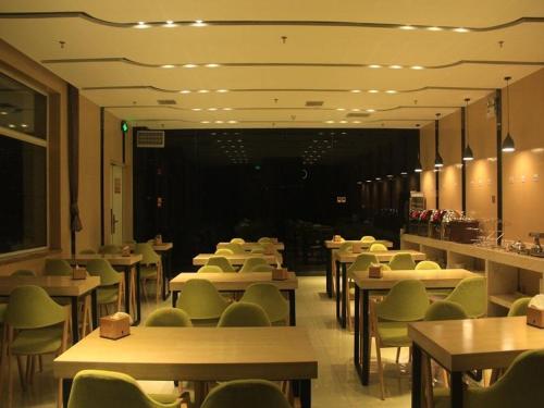 a dining room with tables and green chairs at Lavande Hotel Yinchuan Railway Station Wanda in Yinchuan
