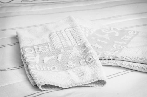 a pair of towels sitting on top of a bed at Hotel Londri Star in Londrina
