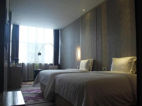 a hotel room with two beds and a window at Lavande Hotel Yinchuan Railway Station Wanda in Yinchuan