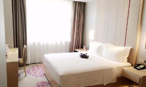 a hotel room with a large white bed and a window at Lavande Hotel Yinchuan Railway Station Wanda in Yinchuan
