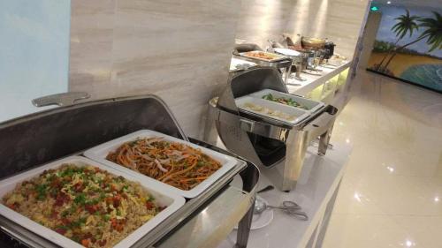 una línea de buffet con platos de comida en un restaurante en Lavande Hotel Huizhou Nan Station Wanda Square, en Huiyangshi