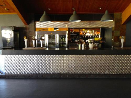 a bar with a counter with vases on it at Town & Country Motor Inn in Forbes