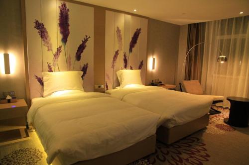 a hotel room with two beds with white sheets at Lavande Hotel Tianshui Gangu Jicheng Square in Tianshui