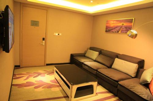 a living room with a couch and a tv at Lavande Hotel Tianshui Gangu Jicheng Square in Tianshui