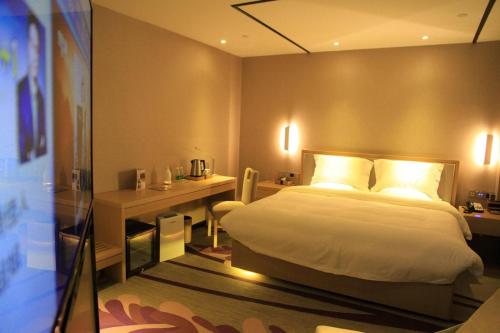 a bedroom with a bed and a desk and a bed sidx sidx sidx at Lavande Hotel Tianshui Gangu Jicheng Square in Tianshui