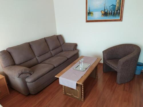 a living room with a couch and a chair at Szilvia Panzió Gyomaendrőd in Gyomaendrőd