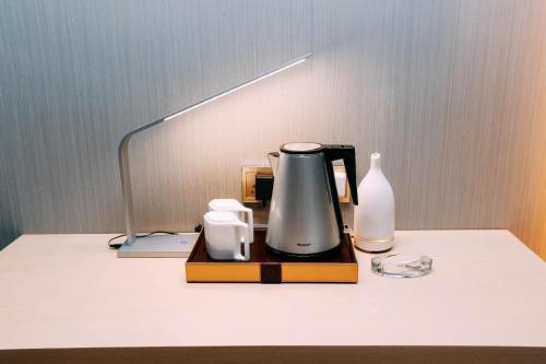a coffee maker and a vase on a table at Lavande Hotel Urumqi High-speed Railway wanda plaza in Ürümqi