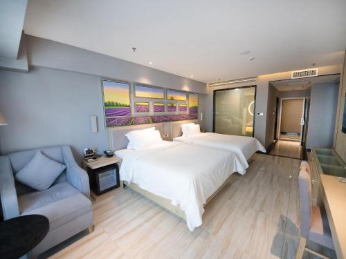 a large bedroom with two beds and a couch at Lavande Hotel Urumqi High-speed Railway wanda plaza in Ürümqi
