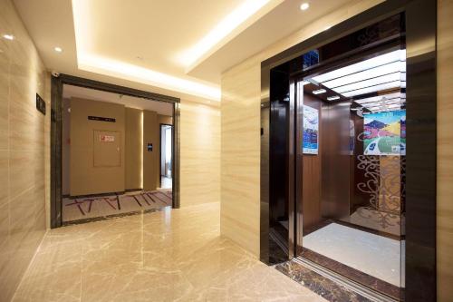 einen Flur mit Spiegel in einem Gebäude in der Unterkunft Lavande Hotel Zhongshan Shaxi in Changzhou