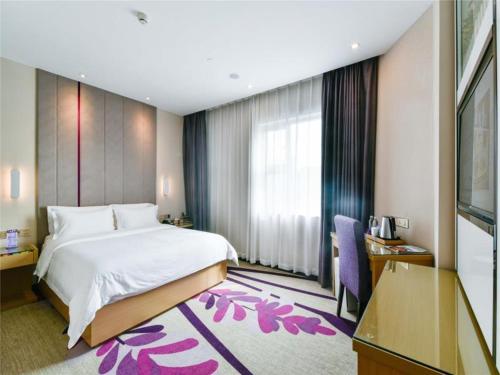 Una habitación de hotel con una cama grande y un escritorio. en Lavande Hotel Qingyuan Flying Lake, en Qingyuan