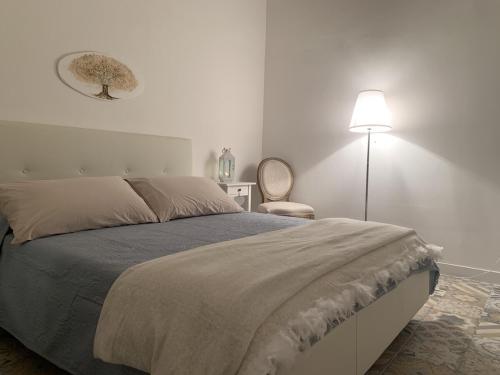 a bedroom with a large bed and a lamp at Il giardino segreto in Taranto