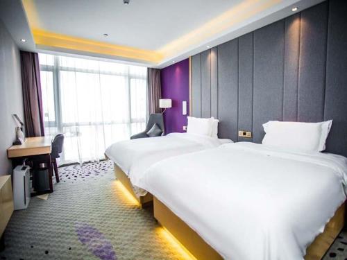a hotel room with two beds and a desk at Lavande Hotel Yanan Pagoda Mountain in Yan'an