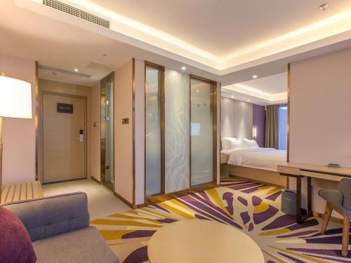 YubeiにあるLavande Hotel Chongqing Jiangbei International Airport Centerのベッドとリビングルームが備わるホテルルームです。