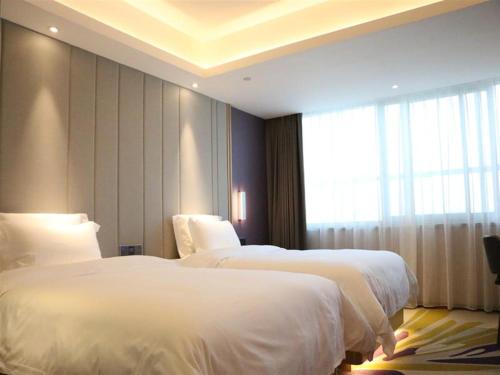 a hotel room with two beds and a window at Lavande Hotel Dongguan Houjie Convention Cente Shanmei subway station in Dongguan