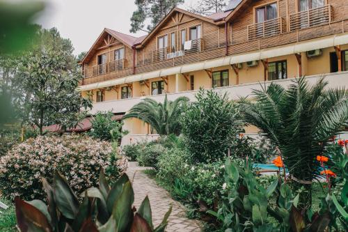 a courtyard of a building with flowers and plants at Keriya Hotel Shekvetili Kaprovani in Shekvetili