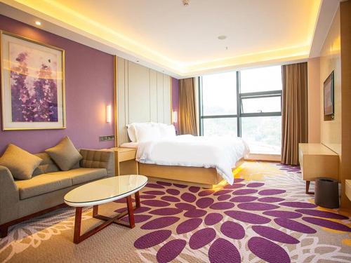 a large hotel room with a bed and a couch at Lavande Hotel Mianyang Santai North Passenger Transport Center Binjiang Park in Mianyang