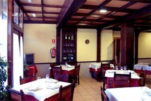 a dining room with white tables and red chairs at Hotel Laberinto in Sigüenza