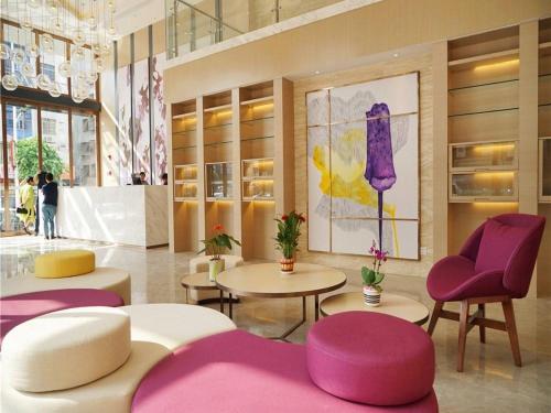 a lobby with purple chairs and tables in a building at Lavande Hotel Heyuan Longchuan in Longchuan
