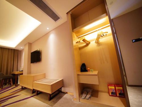 a room with a room with a table and a television at Lavande Hotel Heyuan Longchuan in Longchuan