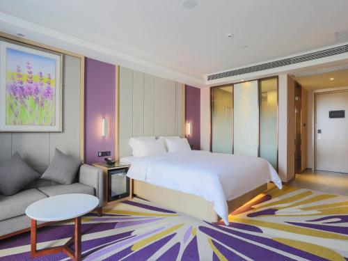 東莞市にあるLavande Hotel Dongguan Liaobu Centerの大きなベッドとソファのある寝室