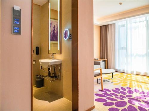 a hotel room with a sink and a bathroom at Lavande Hotel Jiangmen Golf Club in Jiangmen