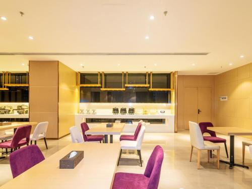 une salle à manger avec des tables et des chaises violettes dans l'établissement Lavande Hotel Anshun West High-speed Rrailway Station, à Anshun