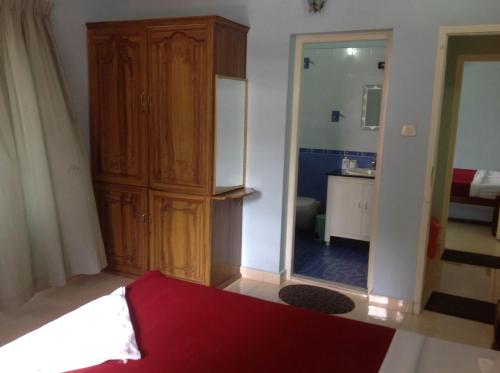 a bedroom with a wooden cabinet and a mirror at Venice Castle in Alleppey
