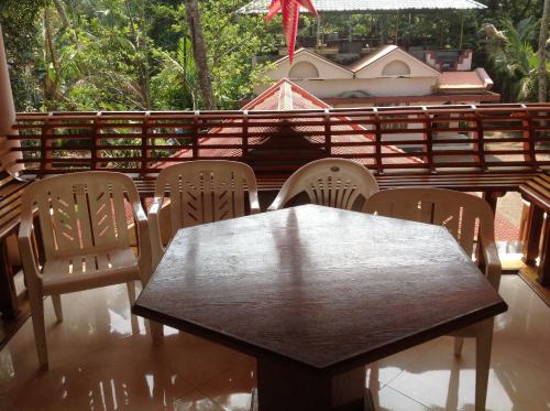 a wooden table and chairs on a patio at Venice Castle in Alleppey