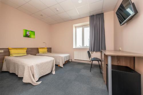 a room with two beds and a flat screen tv at Air Kaunas in Karmėlava