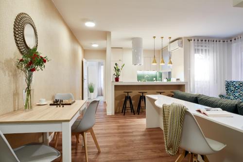 a kitchen and living room with a table and chairs at Cleopatra Apartment in Wrocław