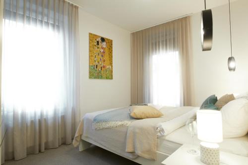 a white bedroom with a bed and a window at Cleopatra Apartment in Wrocław