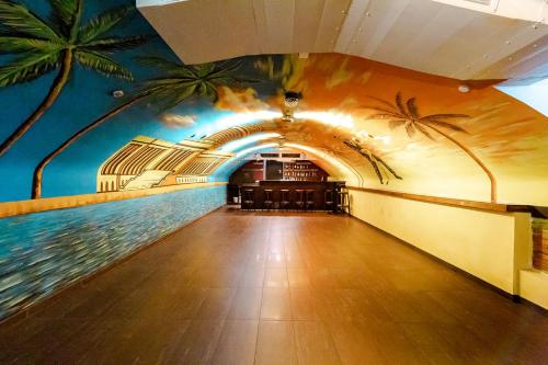 a hallway with a mural of palm trees on the wall at Hotel Havana in Mainz