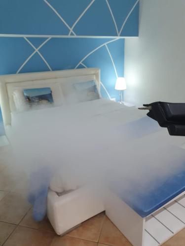 a white bed in a room with a blue wall at Del Cavaliere in Castrovillari