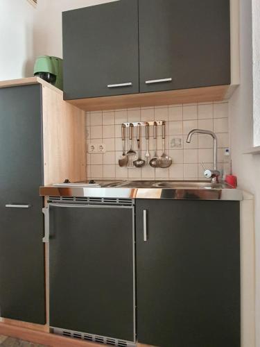 a kitchen with green cabinets and a sink at Landgasthof Waldesruh in Gallspach