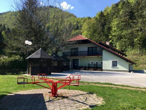 a red bench in the grass in front of a building at Guest House Atelšek in Rečica ob Savinji