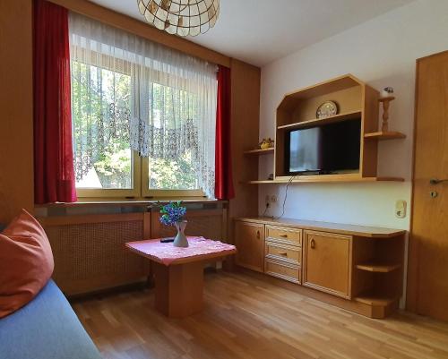 a living room with a tv and a table at Landgasthof Waldesruh in Gallspach