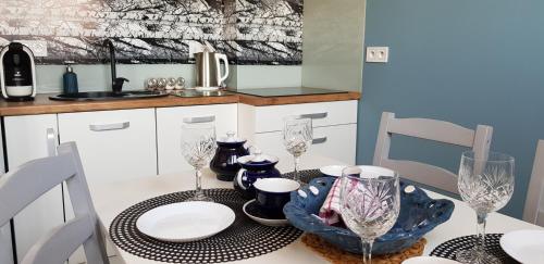 a kitchen with a table with wine glasses on it at Apartament Centrum in Częstochowa