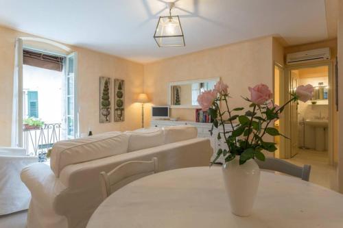 a living room with a couch and a table with flowers at ELEGANTE APPARTAMENTO IN CENTRO in Torri del Benaco
