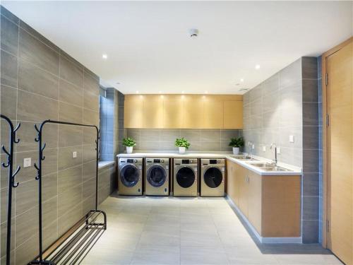 a large laundry room with two washers and a sink at Lavande Hotel Urumqi Beijing South Road Railway Bureau Subway Station in Ürümqi