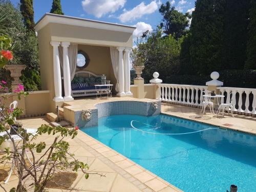 a swimming pool in a backyard with a gazebo at Villa Lugano Guesthouse in Johannesburg