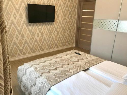 una camera da letto con un letto e una TV a parete di Apartment Sweethome 2 FREE PARKING a Užhorod