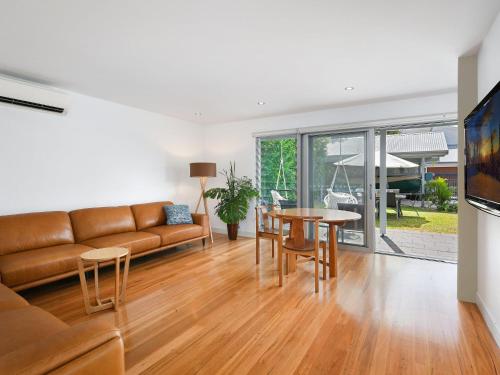 a living room with a couch and a table at Rangoon Sunrise at Minnamurra in Minnamurra